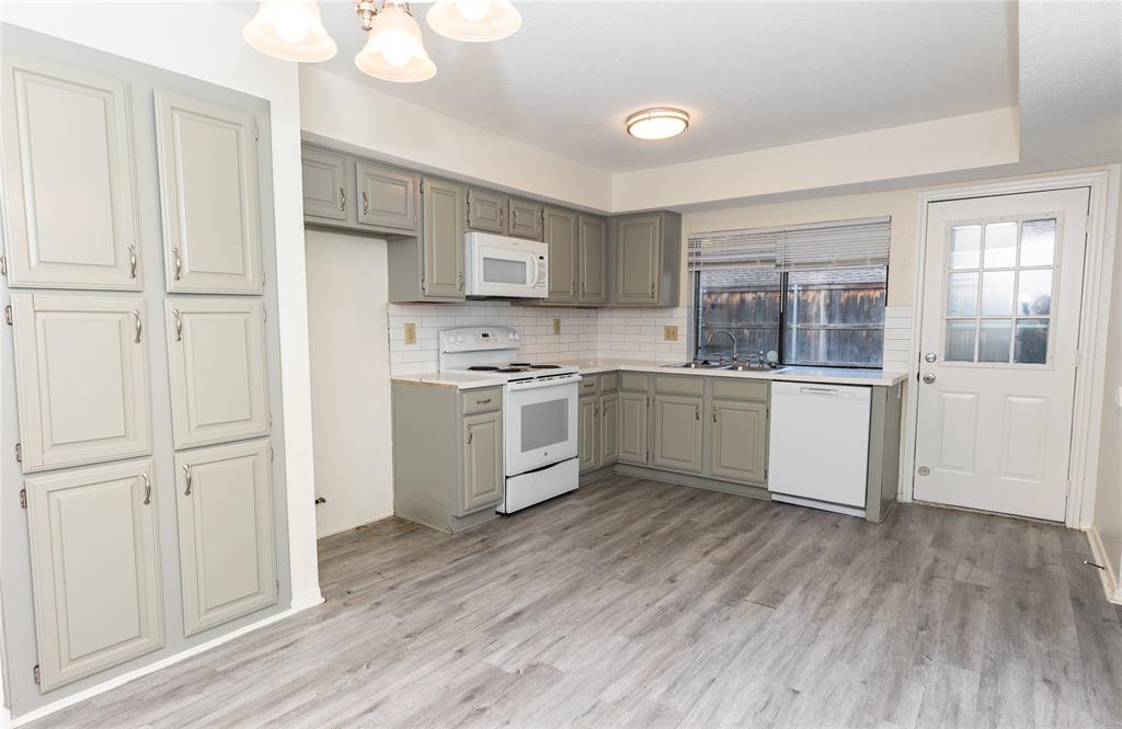 1031 East Peters Colony Road Carrollton, TX 75007 - Photo 5 of 21 a kitchen with cabinets a sink and appliances
