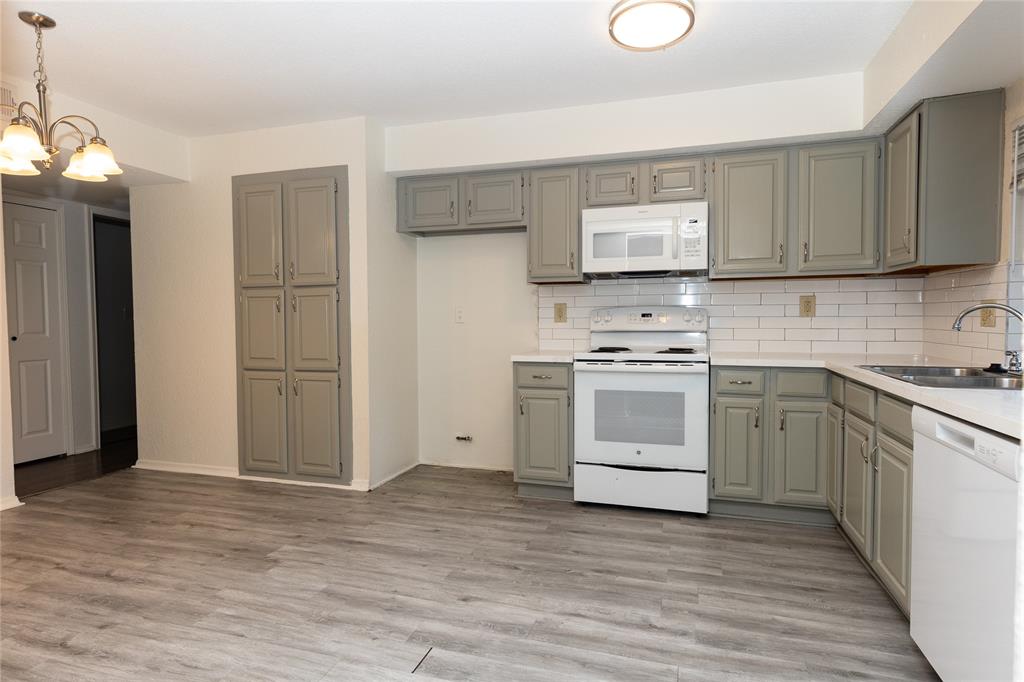 1031 East Peters Colony Road Carrollton, TX 75007 - Photo 6 of 21 a kitchen with a stove cabinets and wooden floor