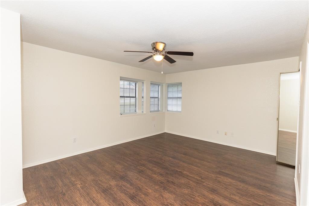 1031 East Peters Colony Road Carrollton, TX 75007 - Photo 7 of 21 a view of empty room with wooden floor and fan