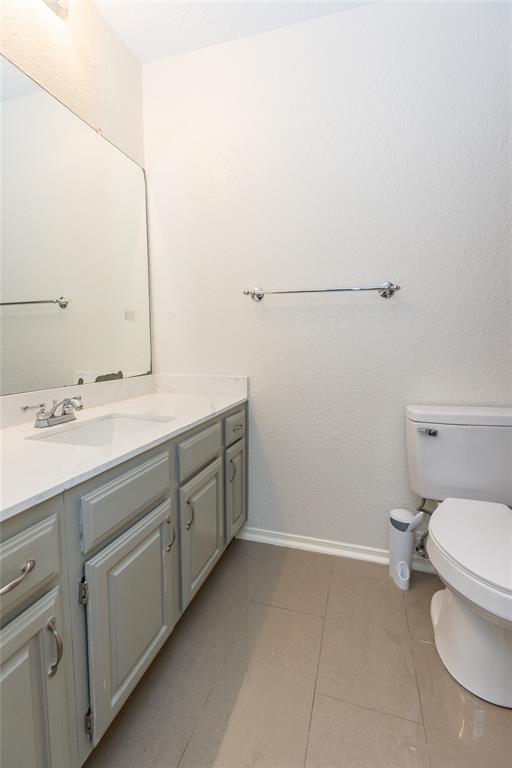 1031 East Peters Colony Road Carrollton, TX 75007 - Photo 9 of 21 a bathroom with a sink toilet and vanity