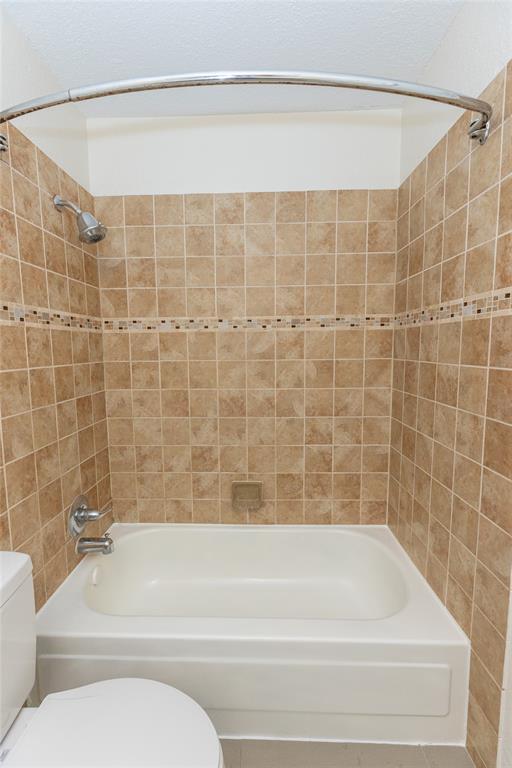 1031 East Peters Colony Road Carrollton, TX 75007 - Photo 10 of 21 a bathroom with a toilet and a bathtub