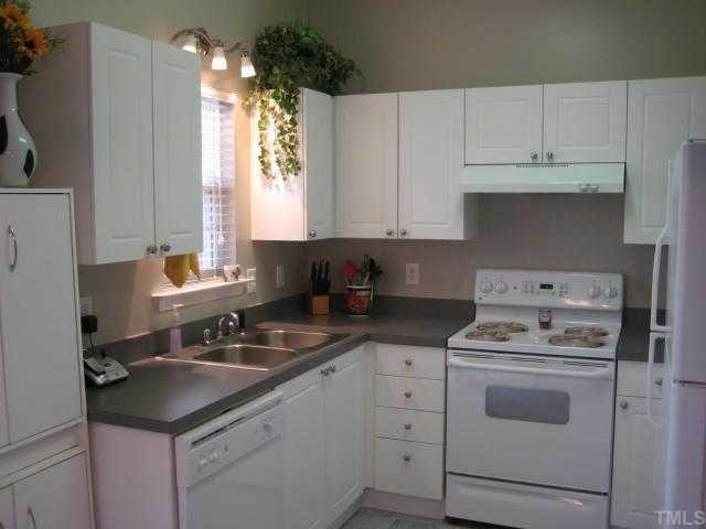 2125 Persimmon Ridge Drive Raleigh, NC 27604 - Photo 3 of 12 a kitchen with white cabinets sink and white appliances