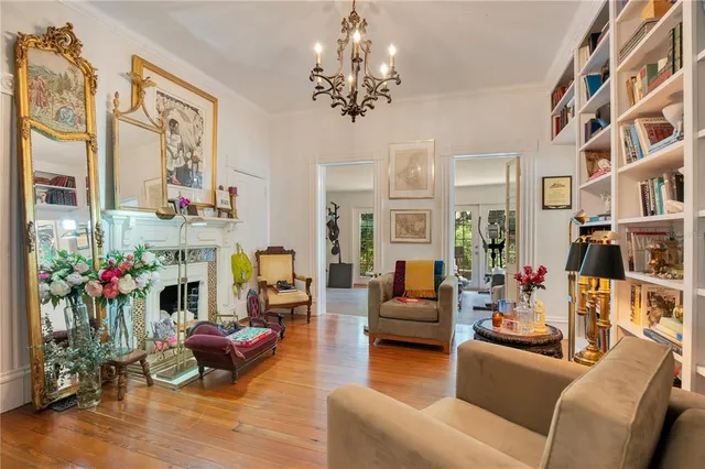 a living room with furniture kitchen view and a wooden floor