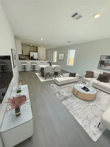 a living room with furniture and a wooden floor