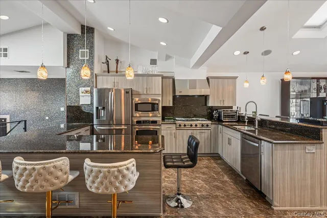 a kitchen with stainless steel appliances kitchen island granite countertop a sink and cabinets