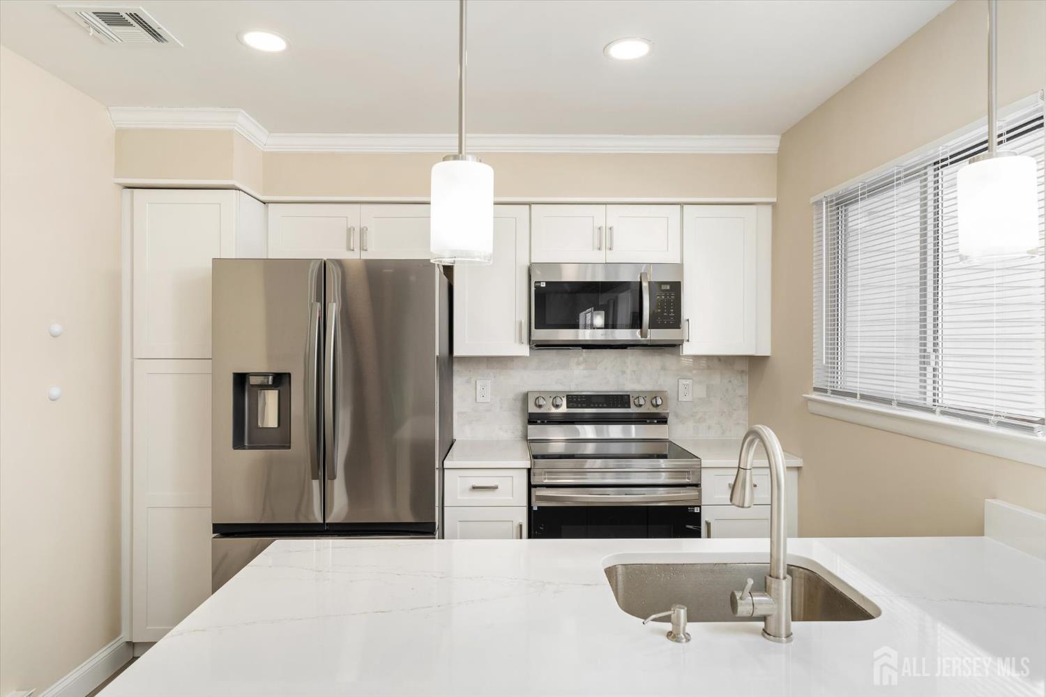769A Marlton Road, Unit B Monroe Township, NJ 08831 - Photo 9 of 24 a kitchen with stainless steel appliances a refrigerator a sink a stove a microwave and island