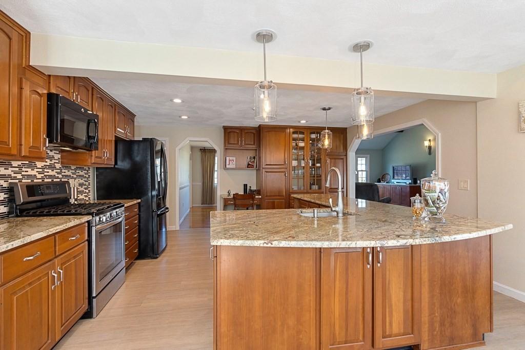 1 Fairview Drive Westford, MA 01886 - Photo 12 of 42 a kitchen with stainless steel appliances granite countertop a sink a stove and a wooden cabinets