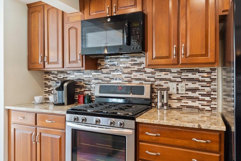 1 Fairview Drive Westford, MA 01886 - Photo 8 of 42 a kitchen with granite countertop a stove top oven cabinetry a sink and stainless steel appliances