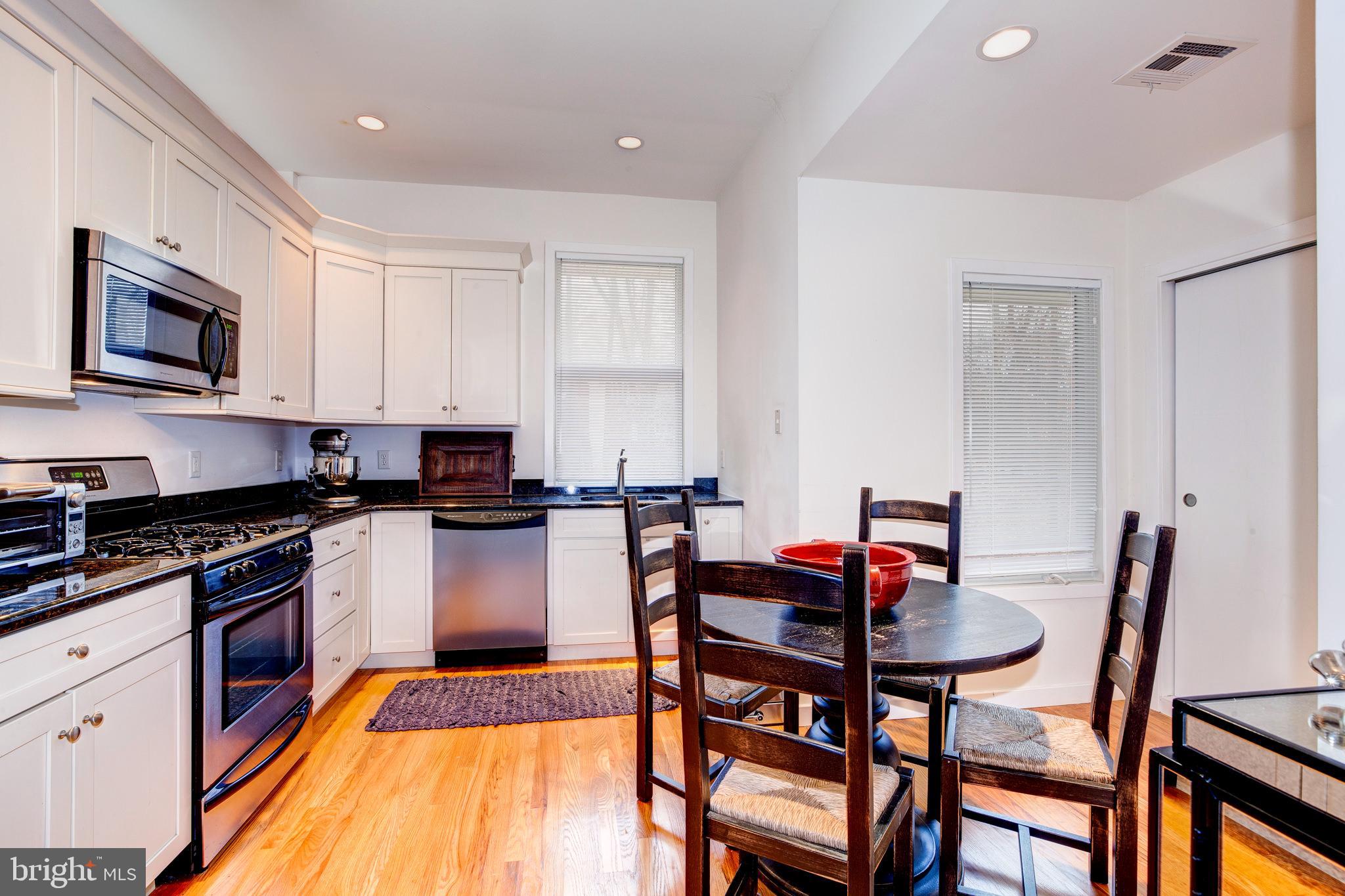 387 A Riverside Drive Princeton, NJ 08540 - Photo 11 of 23 a kitchen with stainless steel appliances granite countertop a stove top oven a sink a dining table and chairs