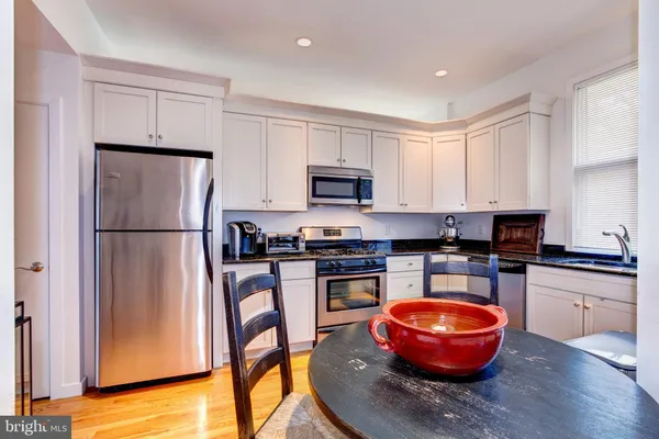 a kitchen with stainless steel appliances granite countertop a stove refrigerator sink and cabinets