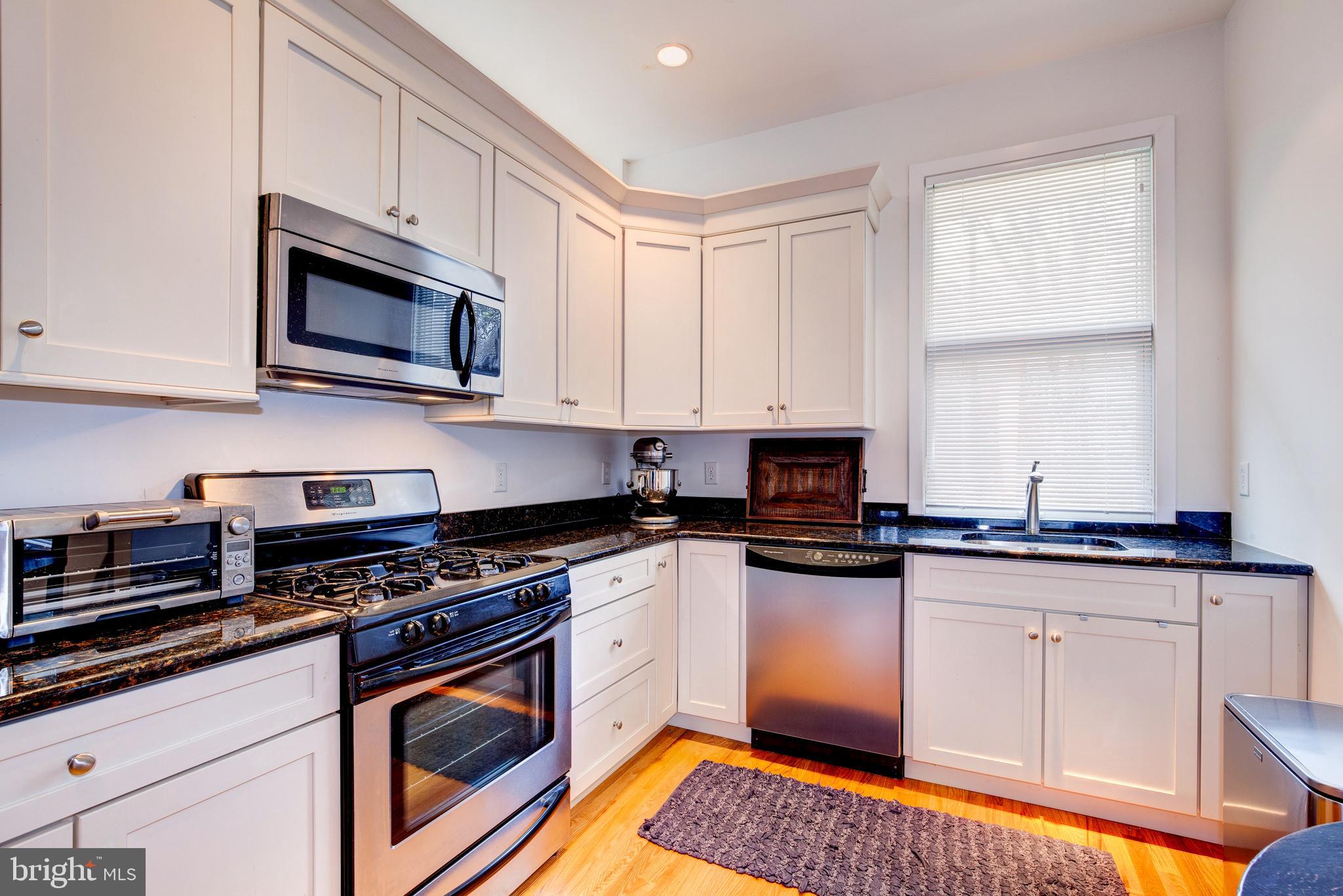 387 A Riverside Drive Princeton, NJ 08540 - Photo 15 of 23 a kitchen with stainless steel appliances granite countertop a stove a sink and a microwave