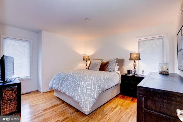 a bedroom with a bed and a flat tv screen on a dresser