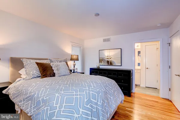 a bed sitting in a bedroom and a night stand