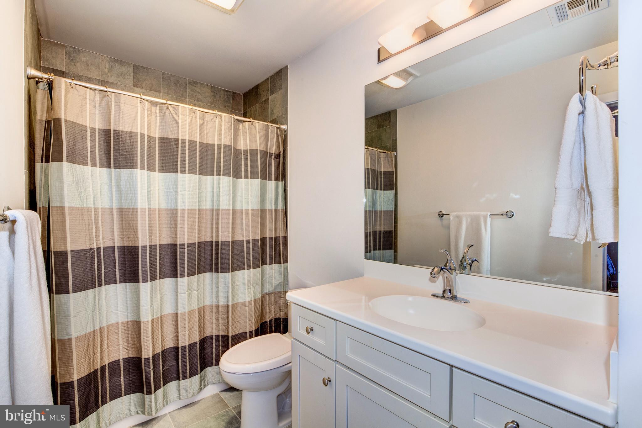 387 A Riverside Drive Princeton, NJ 08540 - Photo 19 of 23 a bathroom with a sink a toilet a mirror and shower curtain