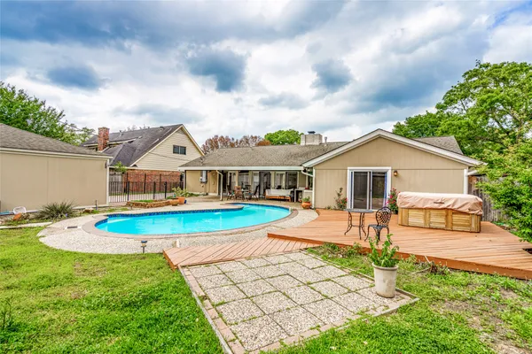 a view of a backyard with swimming pool and plants