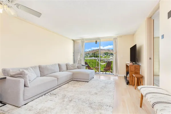 a living room with furniture large window and a flat screen tv