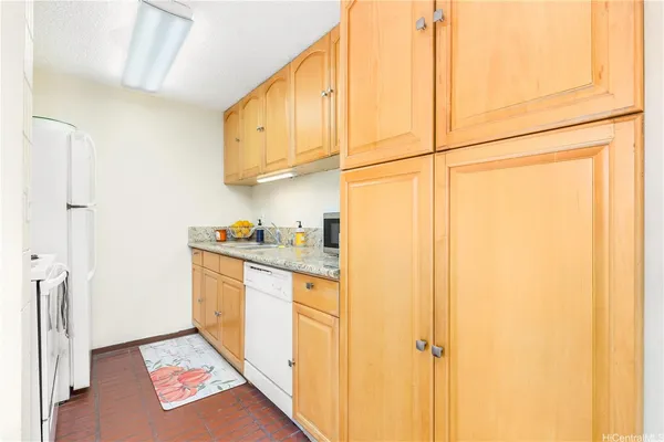 a kitchen with granite countertop cabinets stainless steel appliances and a counter space