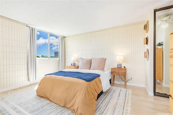 a bedroom with a bed and a large mirror