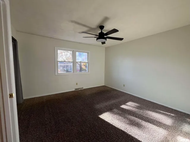 a view of empty room with ceiling fan