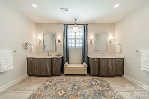 a spacious bathroom with a tub sink and mirror