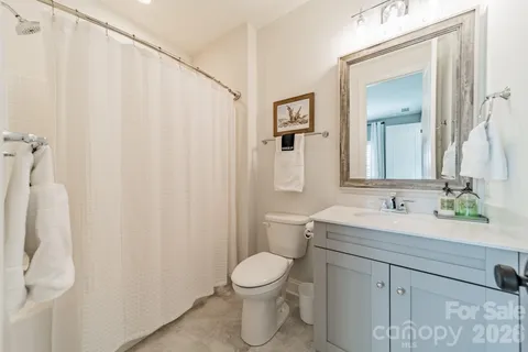 a bathroom with a sink vanity mirror and toilet