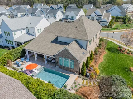 an aerial view of residential houses with yard and swimming pool