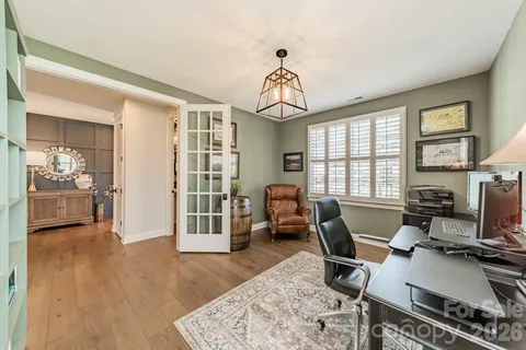 a workspace with wooden floor and a chandelier