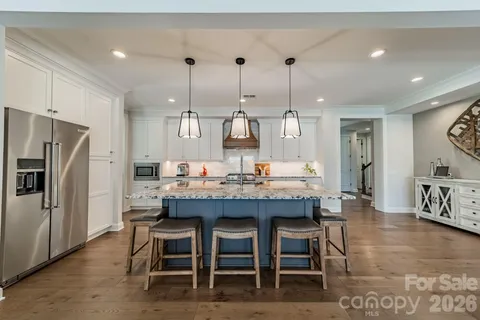 a dining room with furniture a chandelier and kitchen view