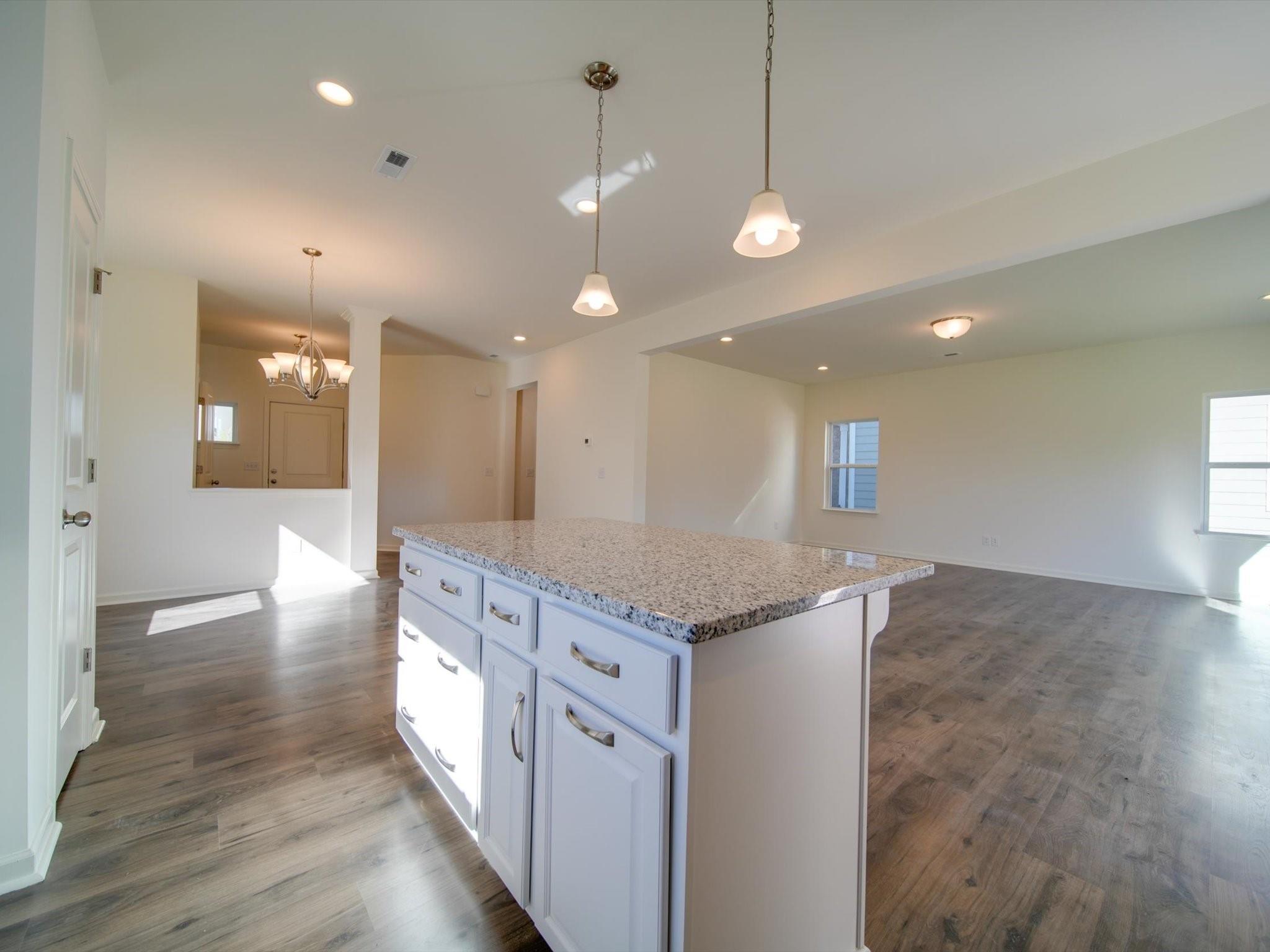1172 Scotch Meadows Loop Monroe, NC 28110 - Photo 12 of 44 a kitchen with stainless steel appliances granite countertop cabinets a island and a chandelier