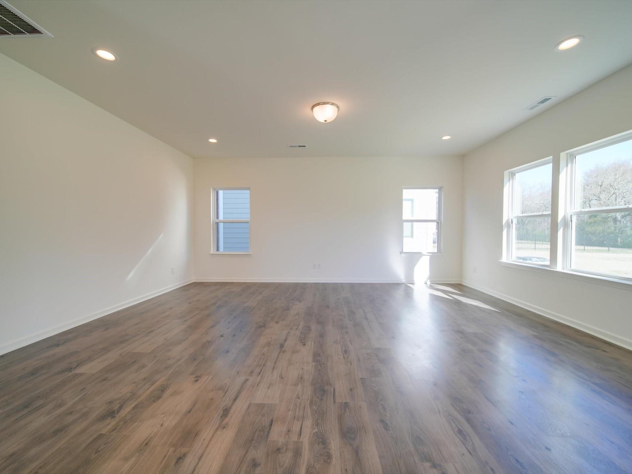 1172 Scotch Meadows Loop Monroe, NC 28110 - Photo 16 of 44 an empty room with wooden floor and windows