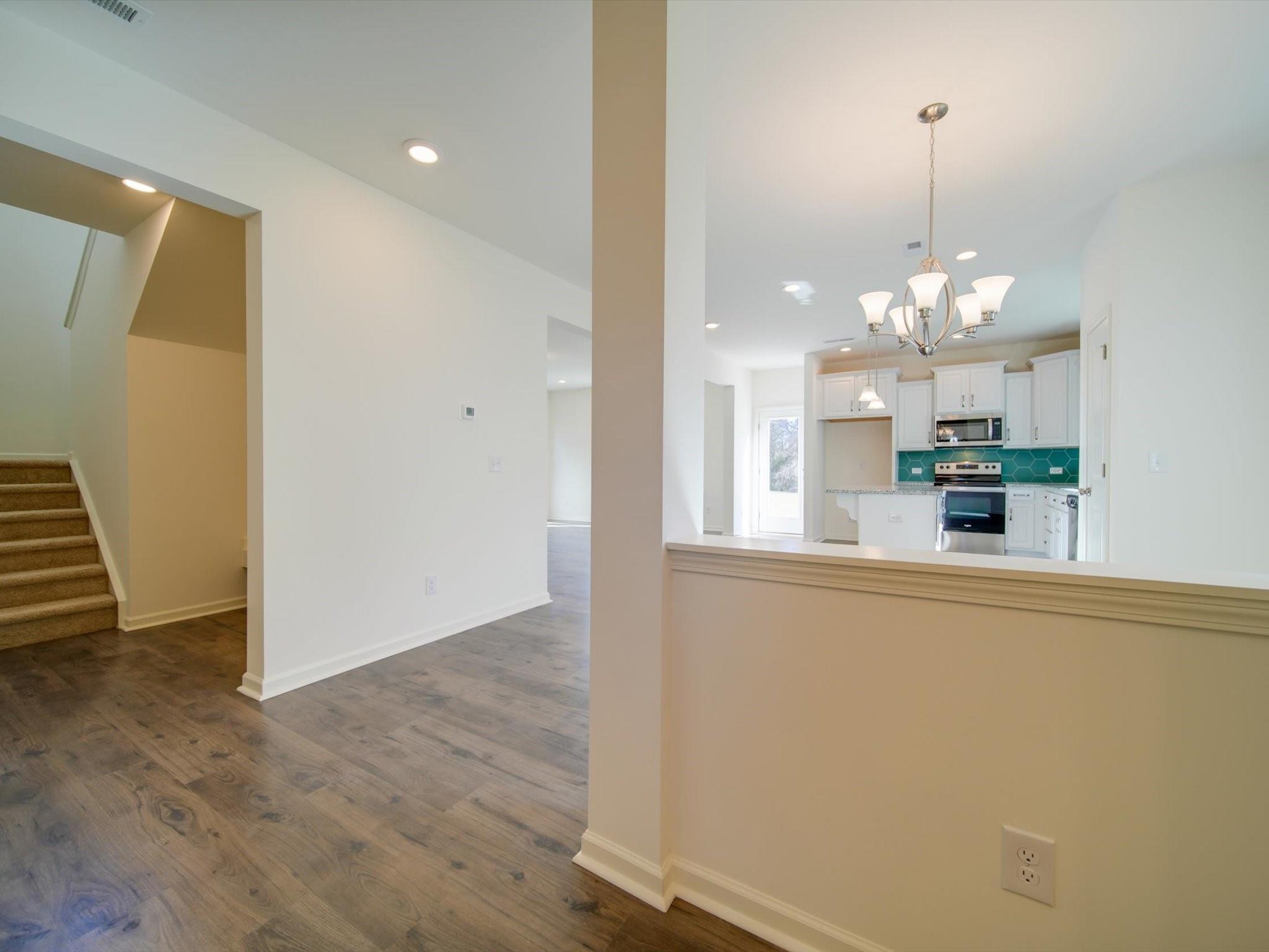 1172 Scotch Meadows Loop Monroe, NC 28110 - Photo 25 of 44 a view of a kitchen with a sink and dishwasher a refrigerator with wooden floor