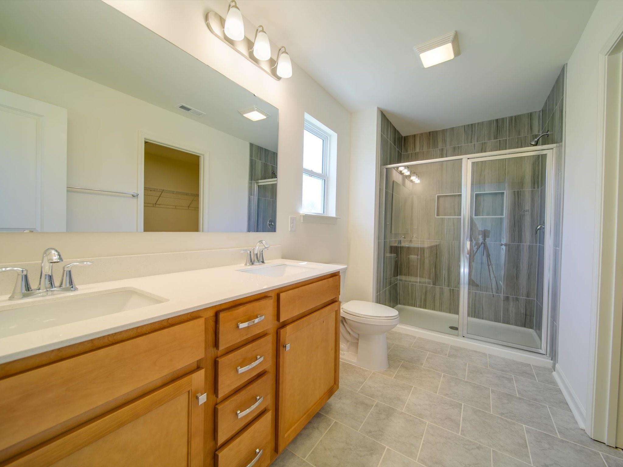 1172 Scotch Meadows Loop Monroe, NC 28110 - Photo 35 of 44 a bathroom with a double vanity sink toilet and shower