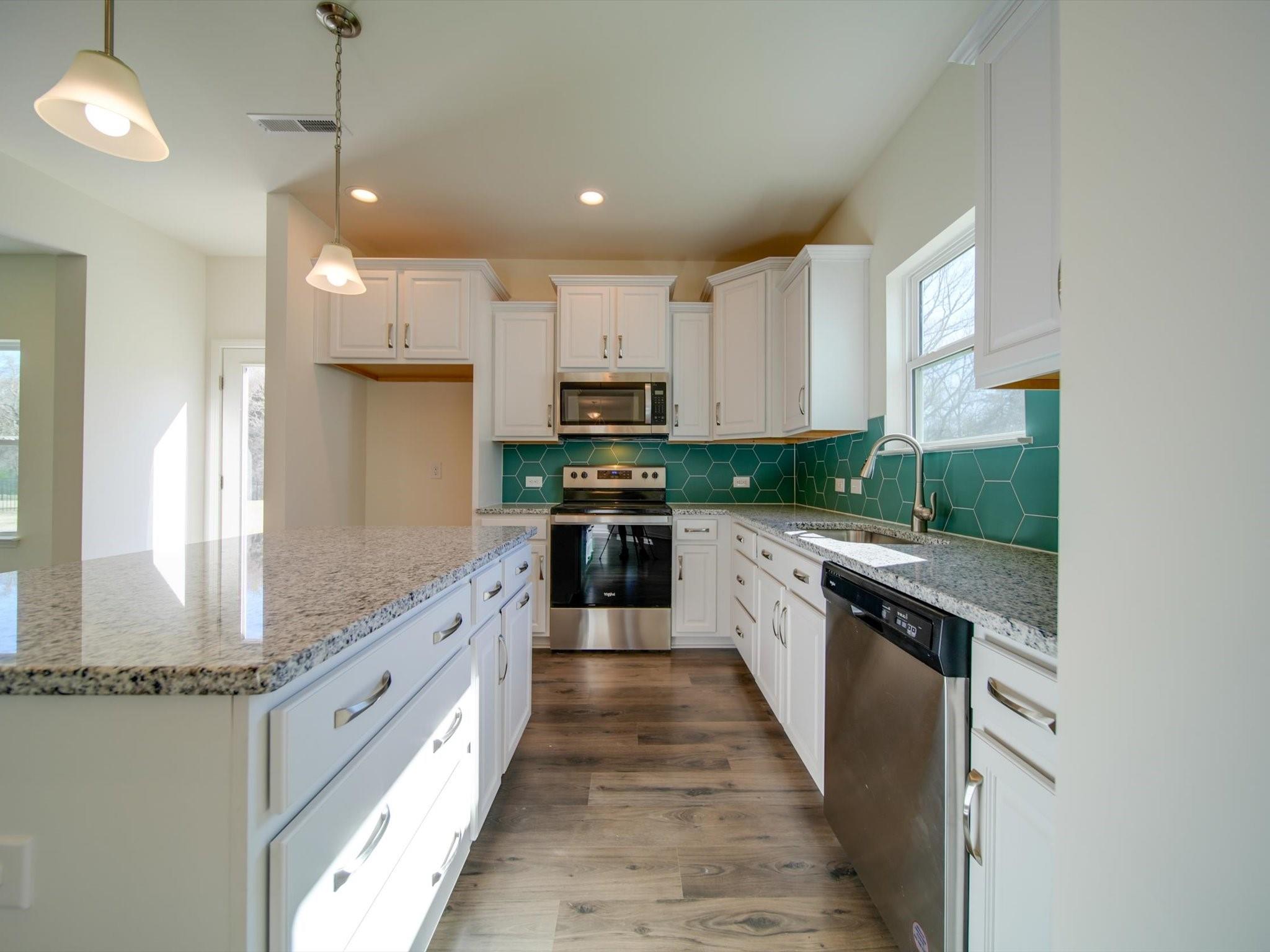 1172 Scotch Meadows Loop Monroe, NC 28110 - Photo 9 of 44 a large kitchen with stainless steel appliances granite countertop a stove a sink and a refrigerator