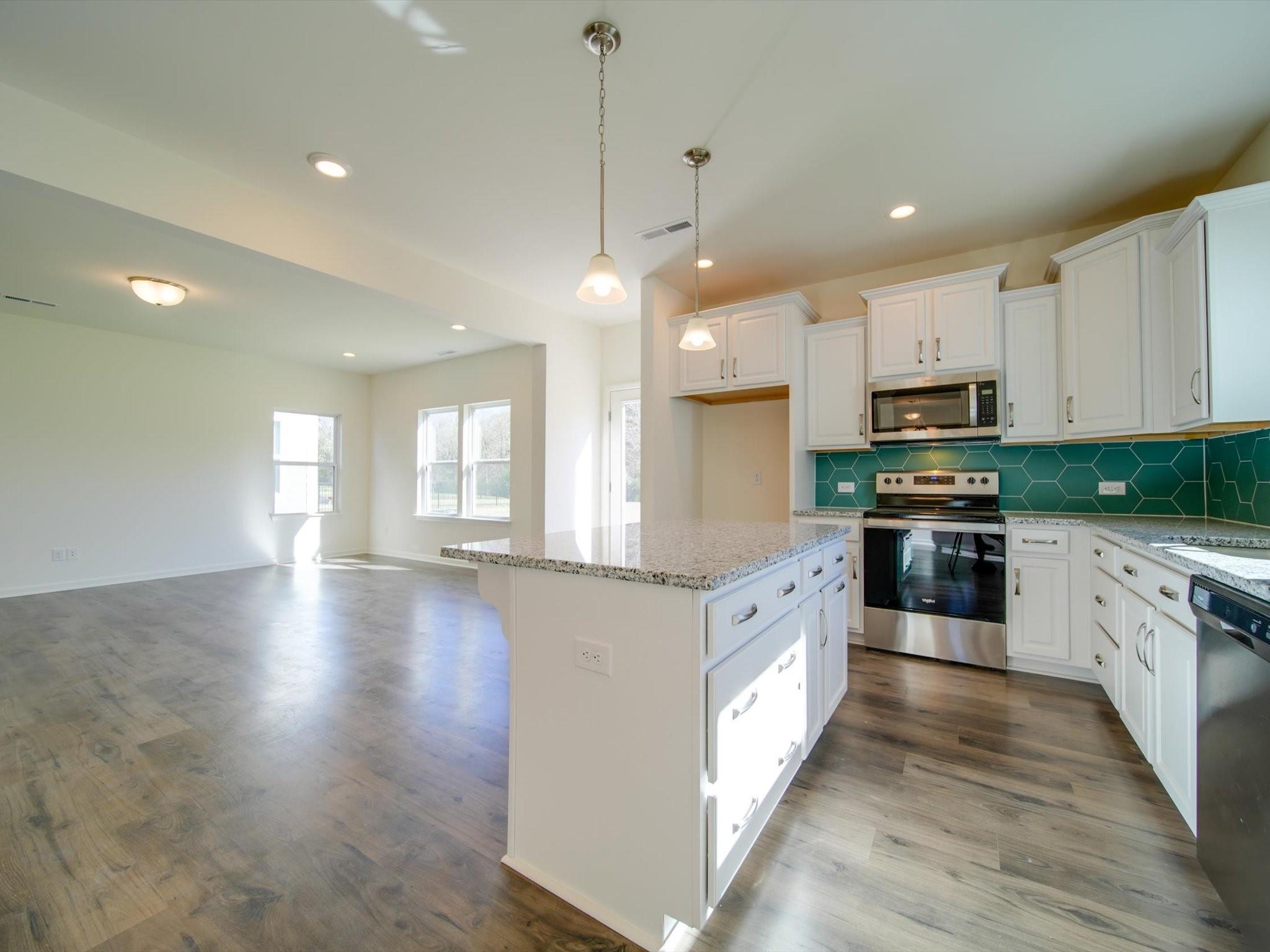 1172 Scotch Meadows Loop Monroe, NC 28110 - Photo 10 of 44 a large kitchen with granite countertop a stove top oven a sink a counter space and cabinets