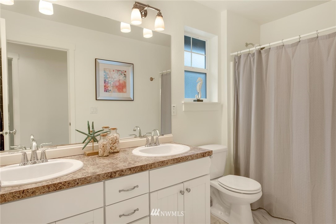 16203 41st Drive Southeast Bothell, WA 98012 - Photo 17 of 20 a bathroom with a granite countertop sink a toilet and a mirror