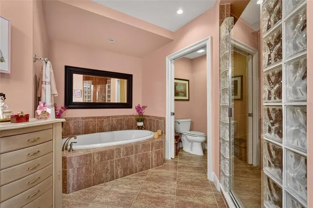 a bathroom with a tub a mirror and a shower