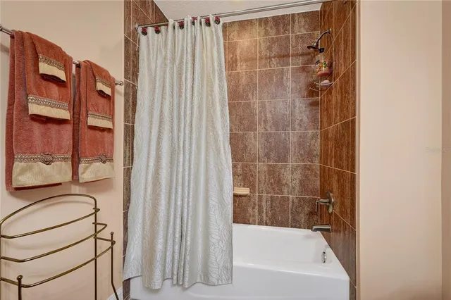 a bathroom with a granite countertop sink a toilet a mirror and shower