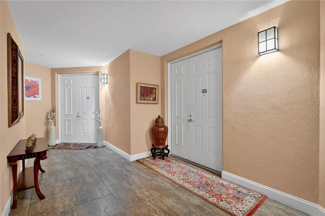 a hallway with painting on the wall and a large mirror