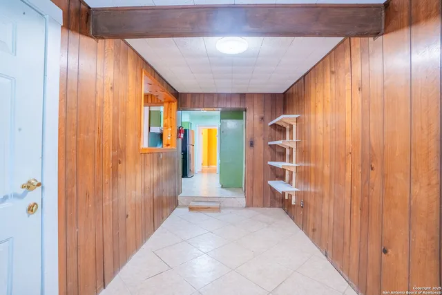 a view of a hallway with wooden shelves