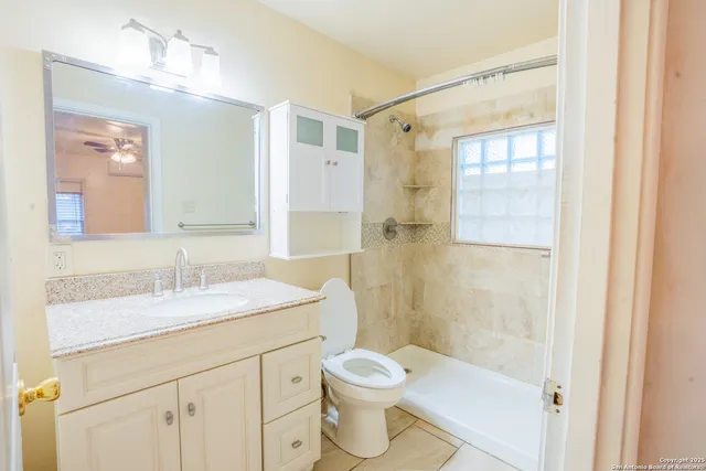 a bathroom with a granite countertop sink toilet and shower