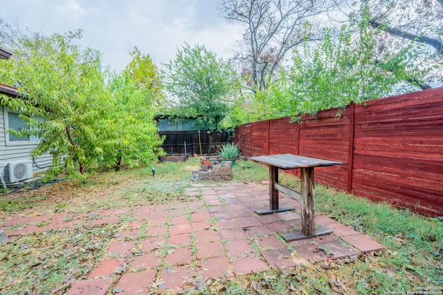 a view of a backyard with a table and chairs under an umbrella