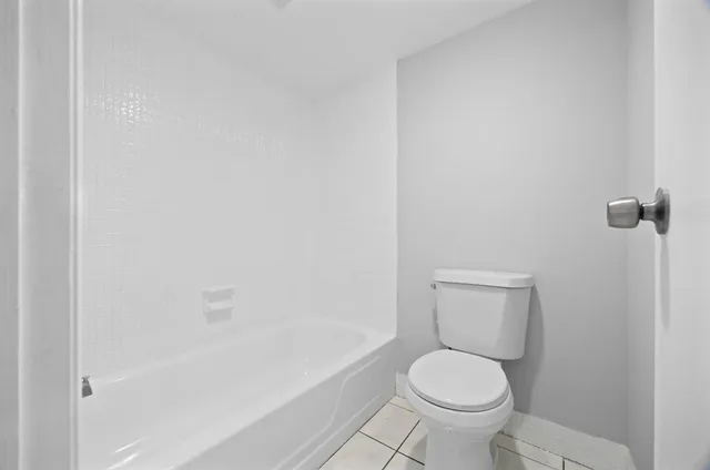 a white toilet sitting next to a bath tub