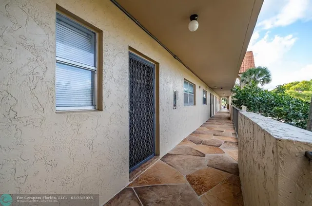 a view of a house with stairs and wooden fence
