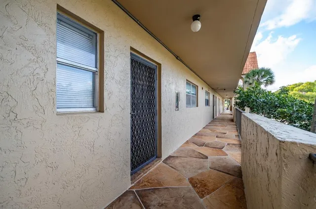 a view of a house with stairs and wooden fence