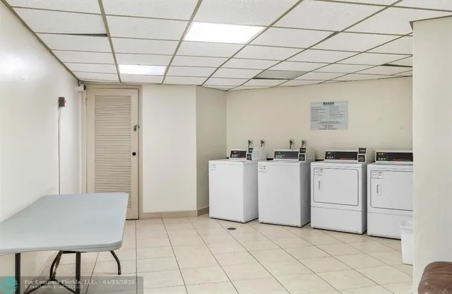 a view of kitchen with refrigerator and white cabinets
