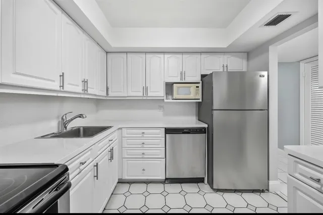 a kitchen with stainless steel appliances granite countertop a refrigerator sink and cabinets