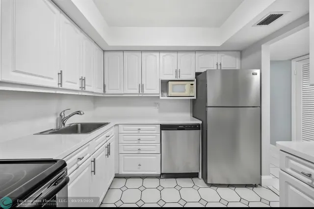 a kitchen with stainless steel appliances granite countertop a refrigerator sink and cabinets