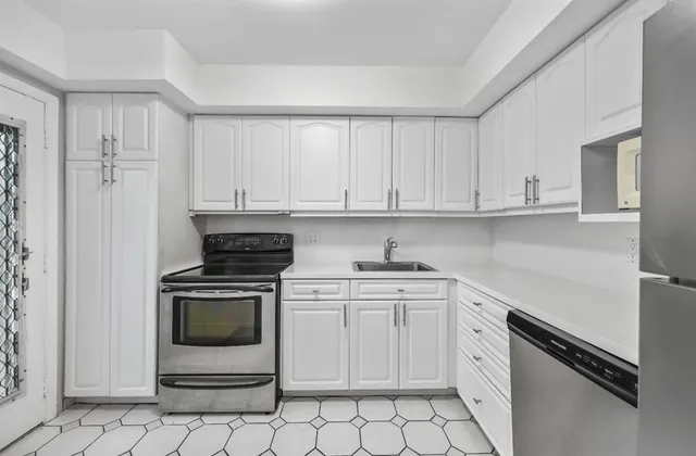a kitchen with white cabinets and appliances