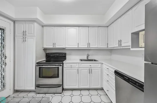 a kitchen with white cabinets and appliances