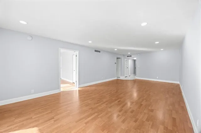 a view of empty room with wooden floor